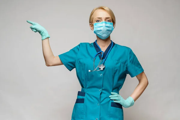 Arts verpleegkundige vrouw met beschermend masker en latex handschoenen - te zien op virtuele lijst — Stockfoto