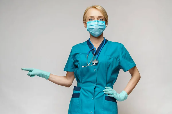 Enfermera médica mujer con máscara protectora y guantes de látex - mostrando en la lista virtual —  Fotos de Stock