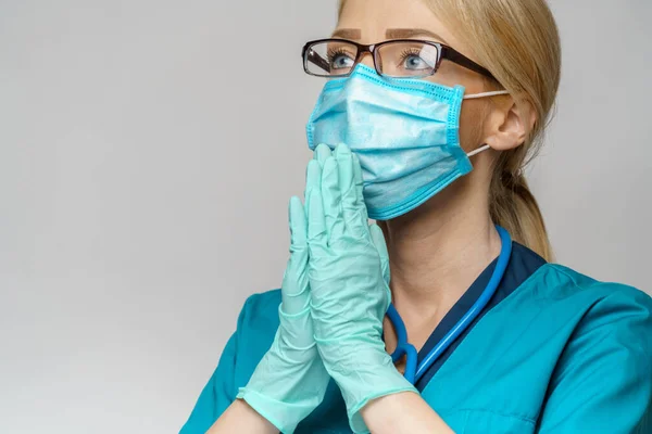 Médico médico enfermera mujer usando máscara protectora y guantes de látex - rezando nad esperando gesto —  Fotos de Stock