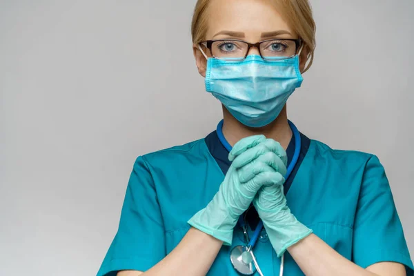 Medical doctor nurse woman wearing protective mask and latex gloves - praying nad hoping gesture — Stock Photo, Image