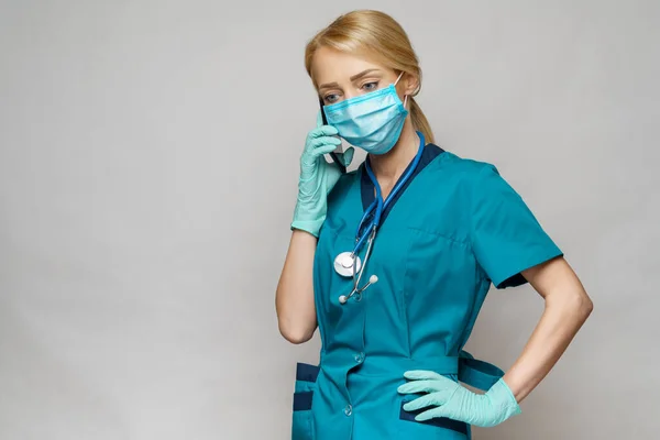 Médico enfermera mujer con máscara protectora y guantes de látex - hablando por teléfono — Foto de Stock