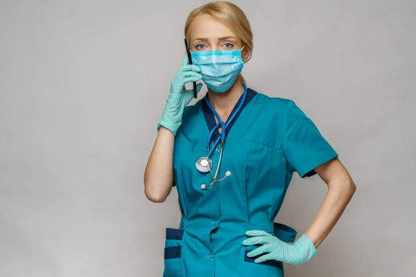 Médico enfermera mujer con máscara protectora y guantes de látex - hablando por teléfono — Foto de Stock