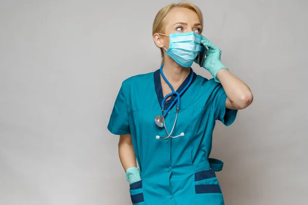 Médico enfermera mujer con máscara protectora y guantes de látex - hablando por teléfono — Foto de Stock