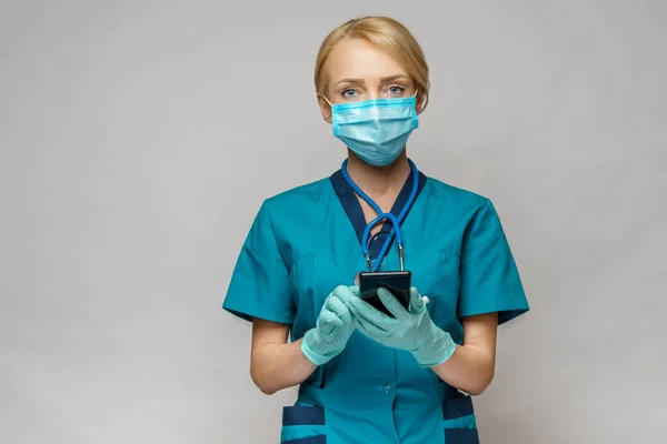 Verpleegkundige vrouw met beschermend masker en latex handschoenen - met behulp van mobiele telefoon — Stockfoto