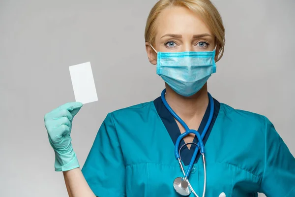 保護マスクと手袋を身に着けている医師看護師の女性-ブランク名刺を表示 — ストック写真