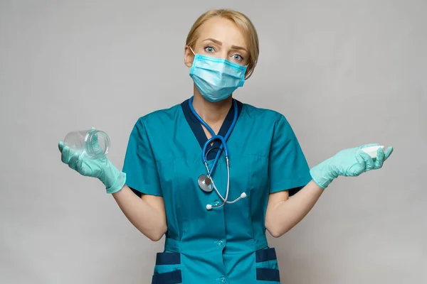 Orvos nővér nő visel védő maszk és kesztyű - gazdaság üres doboz vagy üveg tablettát — Stock Fotó