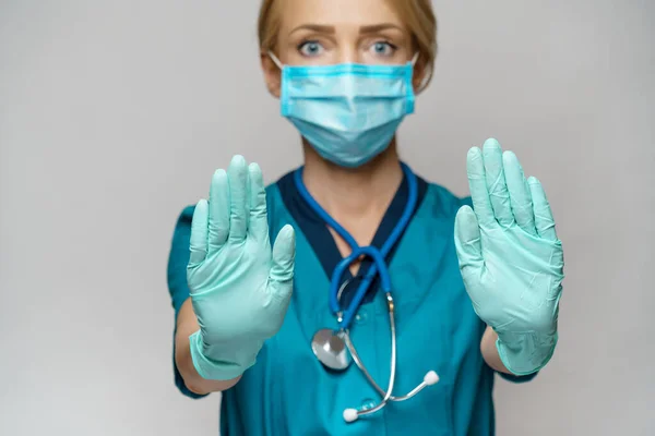 Médico enfermera mujer con máscara protectora y guantes de goma o látex - señal de stop gesto —  Fotos de Stock