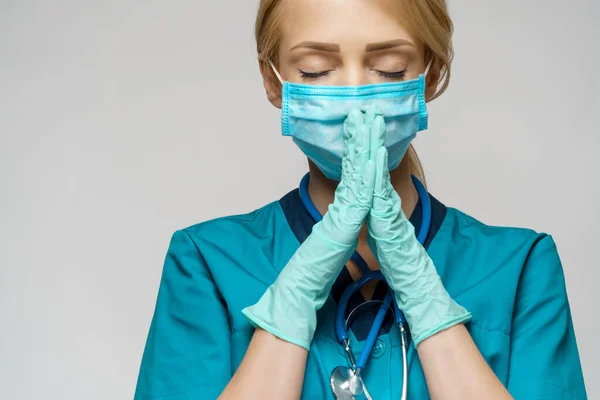 Médico médico enfermera mujer usando máscara protectora y guantes de látex - rezando nad esperando gesto —  Fotos de Stock