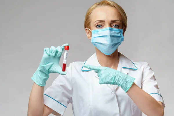 Verpleegkundige vrouw met beschermend masker en handschoenen - virusbloedtest — Stockfoto