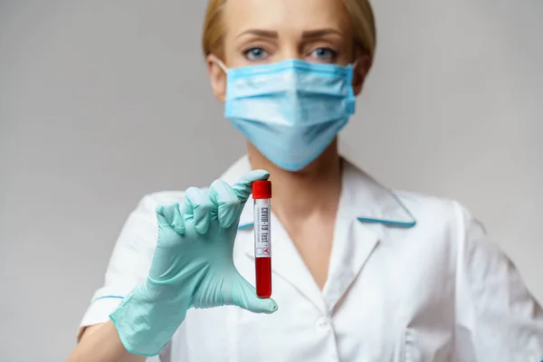 Médico enfermera mujer con máscara protectora y guantes - análisis de sangre del virus de la celebración — Foto de Stock