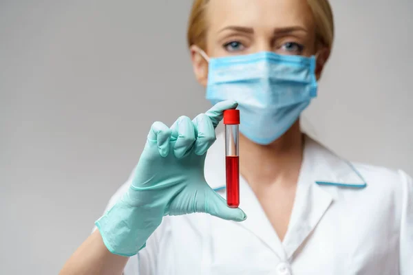 Врач медсестра женщина в защитной маске и перчатках - проведение вирусного анализа крови — стоковое фото