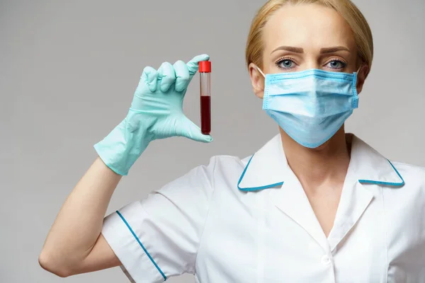 Médico enfermera mujer con máscara protectora y guantes - análisis de sangre del virus de la celebración —  Fotos de Stock