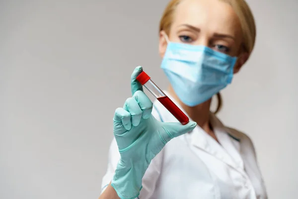 Medical doctor nurse woman wearing protective mask and gloves - holding virus blood test — Stock Photo, Image