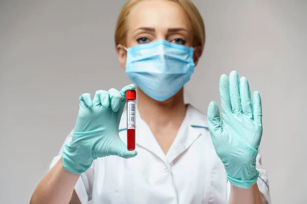 Médico enfermera mujer con máscara protectora y guantes - análisis de sangre del virus de la celebración —  Fotos de Stock