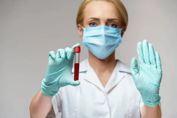 Врач медсестра женщина в защитной маске и перчатках - проведение вирусного анализа крови — стоковое фото