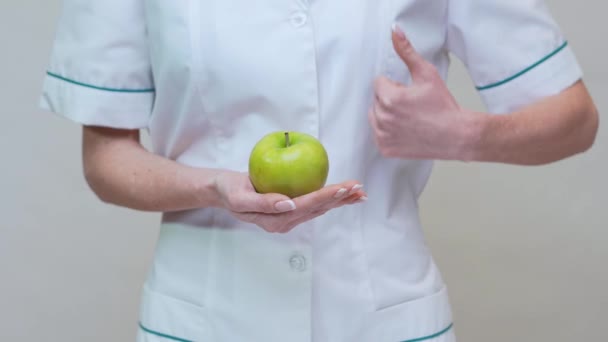 Nutricionista médico concepto de estilo de vida saludable - la celebración de manzana verde orgánica — Vídeos de Stock