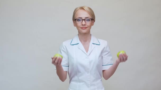 Концепция здорового образа жизни врача-диетолога - держать два органических зеленых яблока — стоковое видео