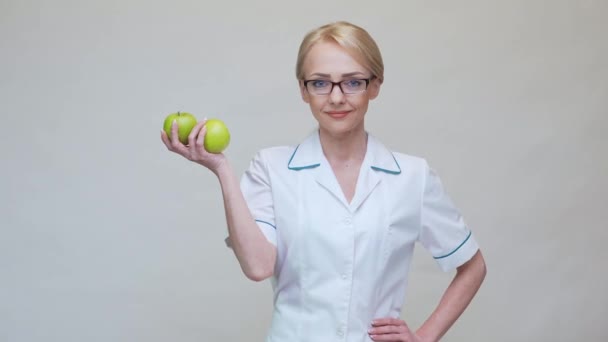 Διατροφολόγος γιατρός έννοια υγιεινού τρόπου ζωής - εκμετάλλευση δύο βιολογικά πράσινα μήλα — Αρχείο Βίντεο