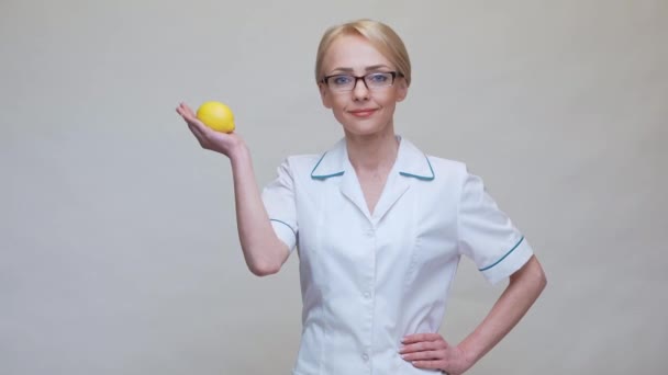Diyetisyen doktor sağlıklı yaşam tarzı konsepti - organik limon meyvesi tutmak — Stok video
