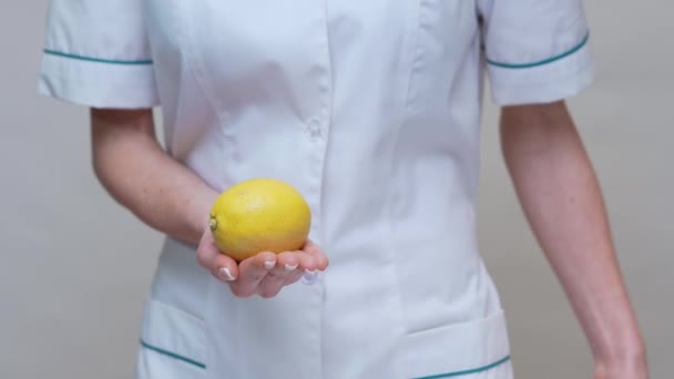 Nutricionista médico concepto de estilo de vida saludable - la celebración de fruta de limón orgánica — Vídeos de Stock