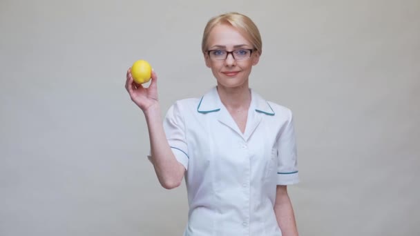 Nutritionist doctor healthy lifestyle concept - holding organic lemon fruit and measurng tape — Stock Video