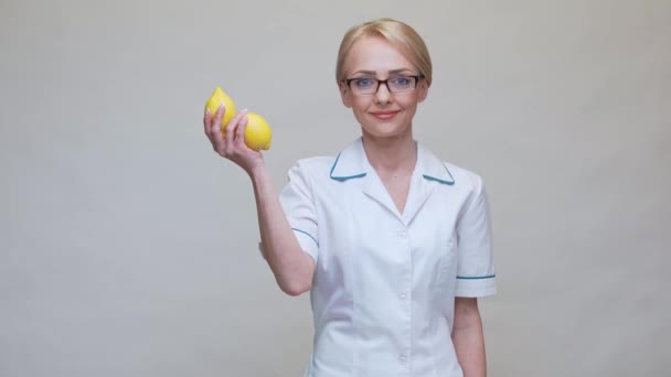 Διατροφολόγος γιατρός έννοια υγιεινού τρόπου ζωής - κρατώντας βιολογικά φρούτα λεμονιού και ταινία μέτρησης — Αρχείο Βίντεο