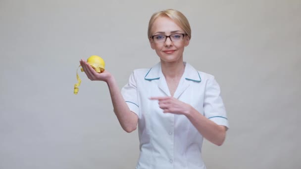 Nutritionist doctor healthy lifestyle concept - holding organic lemon fruit and measurng tape — Stock Video