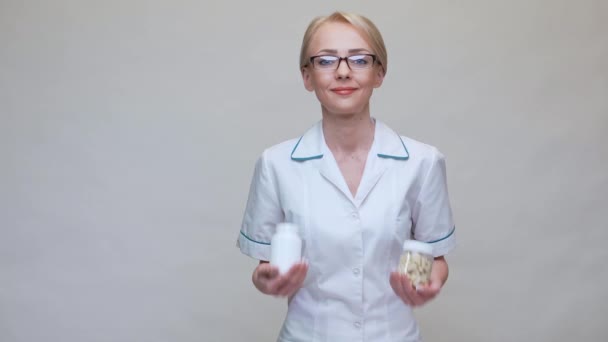 Nutritionist doctor healthy lifestyle concept - holding two jars of vitamin pills — Stock Video