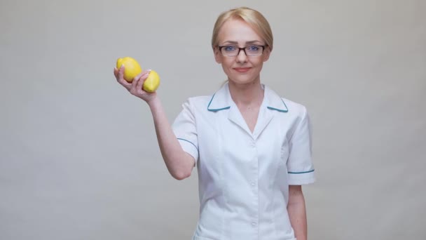 Nutritionist doctor healthy lifestyle concept - holding organic lemon fruit and jar of vitamin pills — Stock Video