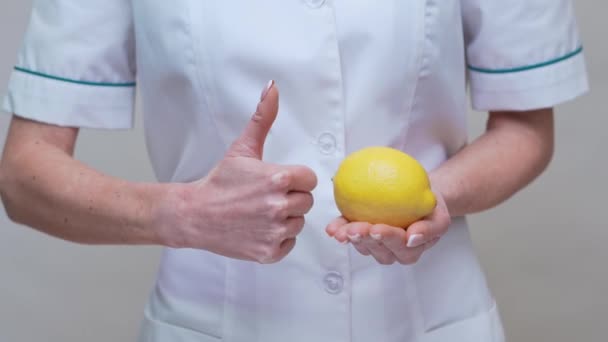 Nutricionista médico concepto de estilo de vida saludable - la celebración de fruta de limón y medicina o píldora de vitamina — Vídeo de stock