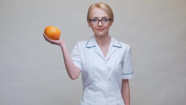 Nutritionist läkare hälsosam livsstil koncept - hålla ekologisk grapefrukt och mäta tejp — Stockvideo