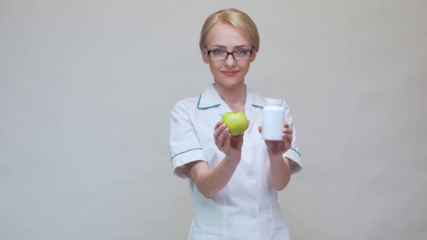 Nutricionista médico concepto de estilo de vida saludable - la celebración de manzana verde orgánica y frasco de píldoras vitamínicas — Vídeo de stock