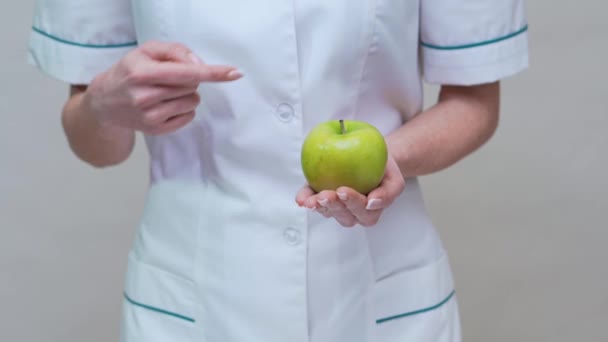 Nutricionista médico concepto de estilo de vida saludable - la celebración de manzana verde y medicamentos o píldoras vitamínicas — Vídeo de stock