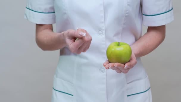 营养学家医生健康的生活方式概念- -持有绿色苹果和药物或维生素丸 — 图库视频影像
