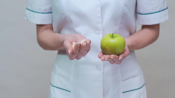 Nutricionista médico concepto de estilo de vida saludable - la celebración de manzana verde y medicamentos o píldoras vitamínicas — Vídeos de Stock