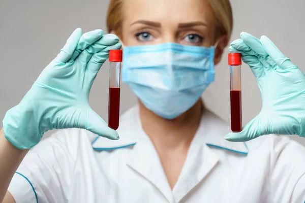 Médico enfermera mujer con máscara protectora y guantes - análisis de sangre del virus de la celebración — Foto de Stock