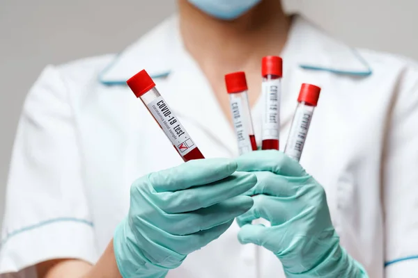 Medical doctor nurse woman wearing protective mask and gloves - holding virus blood test — Stock Photo, Image