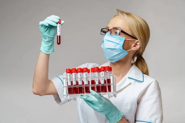 Médico enfermera mujer con máscara protectora y guantes - cremallera con análisis de sangre de virus — Foto de Stock