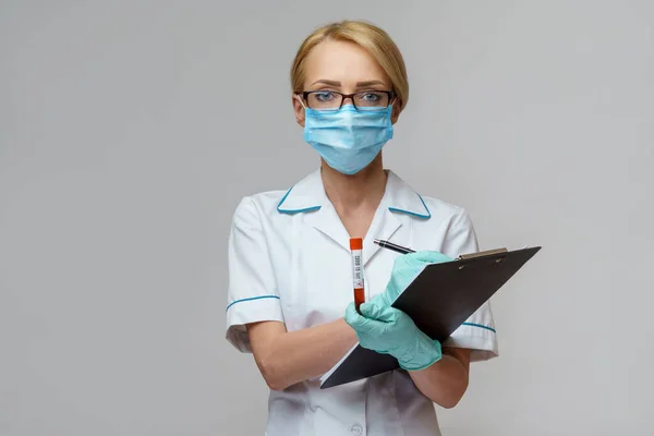 Médico enfermera mujer con máscara protectora y guantes - la celebración de análisis de sangre del virus y la mesa de avión —  Fotos de Stock