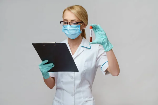 Medische arts verpleegkundige vrouw met beschermende masker en handschoenen - houden virus bloedonderzoek en vliegtuig tafel — Stockfoto