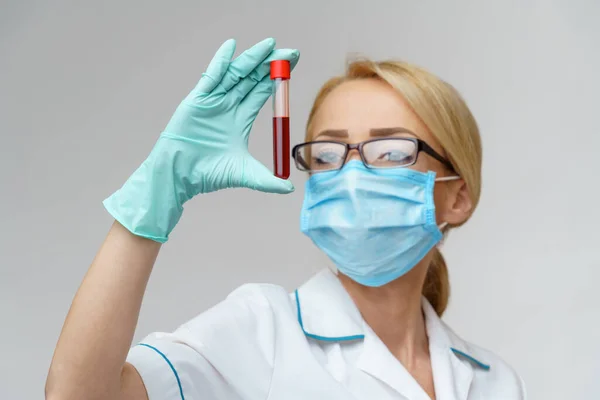 Verpleegkundige vrouw met beschermend masker en handschoenen - virusbloedtest — Stockfoto