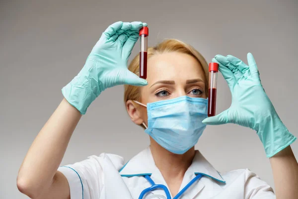 Verpleegkundige vrouw met beschermend masker en handschoenen - virusbloedtest — Stockfoto