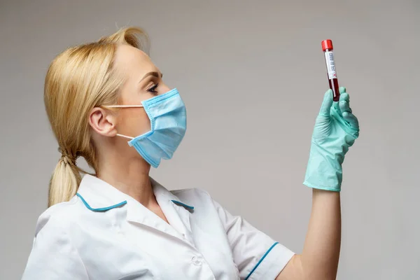 Medico infermiere donna indossando maschera protettiva e guanti - tenendo esame del sangue virus — Foto Stock