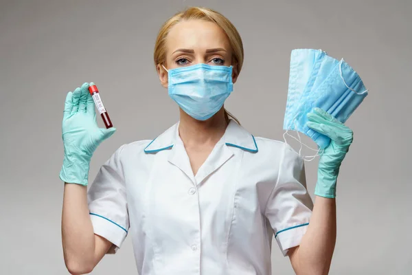 Verpleegkundige vrouw met latex handschoenen - met virusbloedtest en beschermend masker — Stockfoto