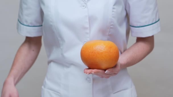 Voedingsdeskundige arts gezonde levensstijl concept - het houden van grapefruit en medicijnen of vitamine pil — Stockvideo