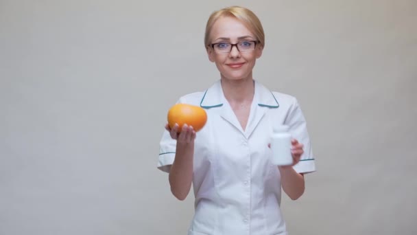 Дієтолог концепція здорового способу життя - тримає органічний грейпфрут і банку вітамінних таблеток — стокове відео