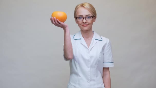 Nutritionist doctor healthy lifestyle concept - holding grapefruit and medicine or vitamin pill — Stock Video