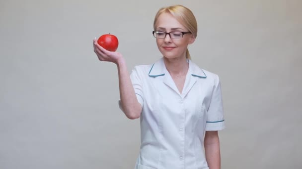 Dietetyk lekarz zdrowy styl życia koncepcja - gospodarstwa organiczne czerwone jabłko i taśma pomiarowa — Wideo stockowe