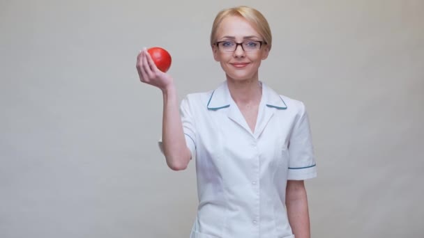 Nutricionista médico concepto de estilo de vida saludable - la celebración de manzana roja orgánica y cinta métrica — Vídeo de stock