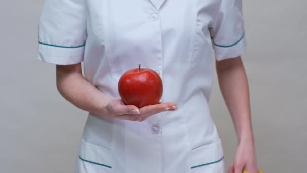 Nutricionista médico conceito de estilo de vida saudável - segurando maçã vermelha orgânica e fita métrica — Vídeo de Stock